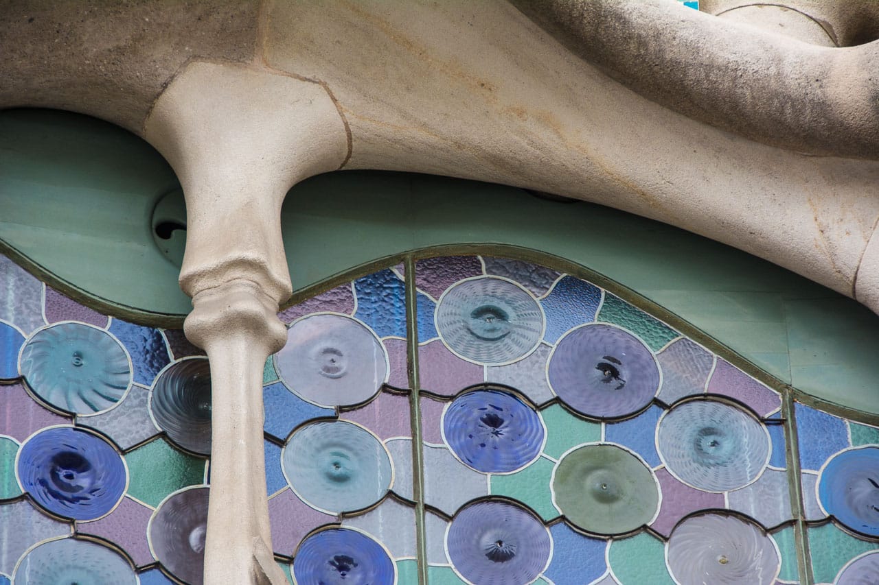 Knochige Säulen, geschwungene Formen und Mosaikelemente: Eine typische Gaudí Fassade